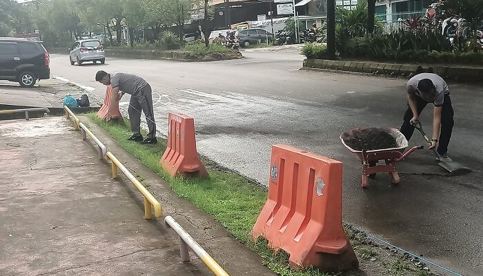Personel Polsek Biringkanaya Bersihkan Endapan Pasir di Jalan Raya